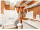 Warm-toned bathroom featuring a skylight, bath tub, and vanity with modern fixtures at 1663 Cloister Dr, Indianapolis, IN 46260