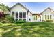Back exterior view of the home featuring a screened-in porch and well-maintained lawn at 1663 Cloister Dr, Indianapolis, IN 46260
