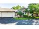 Attractive brick home featuring attached garage and lush landscaping around the facade at 1663 Cloister Dr, Indianapolis, IN 46260
