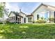 Exterior shot of the home featuring a screened-in porch and beautifully landscaped backyard at 1663 Cloister Dr, Indianapolis, IN 46260