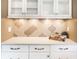Kitchen detailing white cabinets, stainless steel hardware, and decorative backsplash at 1663 Cloister Dr, Indianapolis, IN 46260