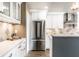 Kitchen features white cabinets, stainless steel refrigerator, and decorative backsplash at 1663 Cloister Dr, Indianapolis, IN 46260