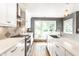 Bright kitchen with white cabinets, modern appliances, and view of the backyard at 1663 Cloister Dr, Indianapolis, IN 46260