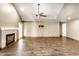 Open living room with hardwood floors, fireplace, and ceiling fan at 1663 Cloister Dr, Indianapolis, IN 46260