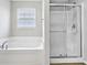 Bathroom with a soaking tub, shower with glass door, and a window for natural light at 1739 Wedgewood Pl, Avon, IN 46123