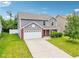 Two story home featuring a two car garage and well manicured lawn at 1739 Wedgewood Pl, Avon, IN 46123