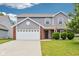 Charming two-story home featuring vinyl siding, red brick accents, and a two-car garage at 1739 Wedgewood Pl, Avon, IN 46123