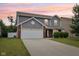 Front exterior of home with a two car garage, long driveway, and combination of brick and siding at 1739 Wedgewood Pl, Avon, IN 46123