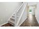 Carpeted staircase and brown tile foyer with a white banister leading to the upper level at 1739 Wedgewood Pl, Avon, IN 46123