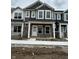 New construction townhome with stone facade, covered entry, and white trimmed windows at 19541 Grassy Branch Rd, Westfield, IN 46074