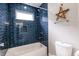 Modern bathroom with blue tiling, a white bathtub, and an overhead shower at 2014 W Michigan St, Indianapolis, IN 46222