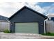 Detached dark gray garage featuring a light green door and a gravel drive at 2014 W Michigan St, Indianapolis, IN 46222