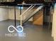 Unfinished basement with concrete floor and exposed duct work and staircase at 2028 Gilmore St, Columbus, IN 47201