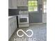 Kitchen featuring laminate countertops, white cabinets, and gas range at 2028 Gilmore St, Columbus, IN 47201