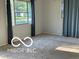 Bright living room featuring neutral walls, carpet, large windows with stylish curtains, and ample natural light at 2028 Gilmore St, Columbus, IN 47201