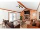 Cozy living room boasting a brick fireplace, wood paneling, ceiling fan and leather furniture at 206 Banbury Rd, Noblesville, IN 46062