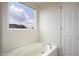 Bright bathroom featuring tub, window, and white door at 2101 Shadow Fox Dr, Columbus, IN 47201