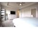 Bright primary bedroom with neutral walls, gray carpet, large bed, and an adjacent bathroom at 2101 Shadow Fox Dr, Columbus, IN 47201