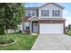 Charming two-story home with brick facade, blue shutters, landscaped yard, and a two-car garage at 2101 Shadow Fox Dr, Columbus, IN 47201