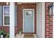 Front door detail with blue paint, glass pane, and a welcome mat, complemented by brick and siding at 2101 Shadow Fox Dr, Columbus, IN 47201