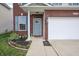 Close-up of the brick-facade home featuring a blue front door, brick surround, and flower bed at 2101 Shadow Fox Dr, Columbus, IN 47201