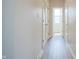 Hallway with wood floors and white walls, offering access to multiple rooms and closet storage at 2101 Shadow Fox Dr, Columbus, IN 47201