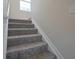 Carpeted staircase with neutral walls and simple white trim at 2101 Shadow Fox Dr, Columbus, IN 47201