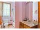 Bright bathroom with pink walls, a window providing natural light, and classic fixtures at 239 E 11Th St, Indianapolis, IN 46202