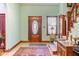 Inviting foyer with a decorative front door, ornate staircase and vintage furniture at 239 E 11Th St, Indianapolis, IN 46202
