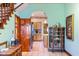Spacious foyer featuring hardwood floors, a vintage cabinet and staircase at 239 E 11Th St, Indianapolis, IN 46202
