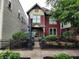 Attractive two-story home with a black iron fence, lush greenery and an American flag at 239 E 11Th St, Indianapolis, IN 46202