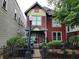 Inviting red two-story house with a black iron fence and well-maintained yard at 239 E 11Th St, Indianapolis, IN 46202
