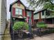 Beautiful red and green two-story home with a well-kept lawn and street light at 239 E 11Th St, Indianapolis, IN 46202