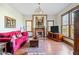 Bright living room with a red velvet sofa, decorative fireplace and hardwood floors at 239 E 11Th St, Indianapolis, IN 46202