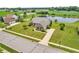 Aerial view of a brick home with a large yard near a serene pond with fountain at 2948 Chalbury Dr, Plainfield, IN 46168