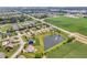 Expansive aerial view highlighting neighborhood homes near a tranquil pond and farmland at 2948 Chalbury Dr, Plainfield, IN 46168