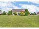 Lush green backyard with mature trees and landscaping with partial home exterior view at 2948 Chalbury Dr, Plainfield, IN 46168