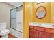 Brightly painted basement bathroom features shower, vanity and decorative round mirror at 2948 Chalbury Dr, Plainfield, IN 46168