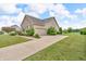 Side view of home with a large driveway, manicured lawn, and partial brick facade at 2948 Chalbury Dr, Plainfield, IN 46168