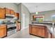 Well-equipped kitchen with stainless steel appliances, wood cabinetry, and tile flooring at 2948 Chalbury Dr, Plainfield, IN 46168