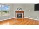 Cozy living room showcasing a fireplace, hardwood floors, and a view of the backyard at 2948 Chalbury Dr, Plainfield, IN 46168