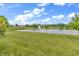 Peaceful view of a pond with a fountain, bordered by lush green lawn and mature trees at 2948 Chalbury Dr, Plainfield, IN 46168