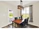 Sunlit dining area with wooden table, elegant lighting, and views of the landscaped exterior at 3301 N 200 W, Franklin, IN 46131