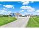 Beautiful home with a gravel driveway leading to a garage and American flag, surrounded by lush greenery at 3301 N 200 W, Franklin, IN 46131