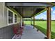 Covered outdoor porch provides comfort and views of the peaceful green farmland at 3301 N 200 W, Franklin, IN 46131