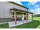 Relaxing covered porch with concrete floor, outdoor chairs, and pastoral views in the background at 3301 N 200 W, Franklin, IN 46131