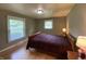 This bedroom features a comfortable bed, two bright windows, and hardwood floors at 386 Shadow Hill Dr, Greenwood, IN 46142