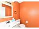 A vibrant bathroom features orange walls and a white vanity, creating a cheerful space at 392 Aspen Dr, Carmel, IN 46032