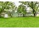The house has a small, green storage shed and a sliding glass door at 415 N 3Rd St, Elwood, IN 46036