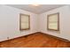 Bedroom with hardwood floors, natural light from two windows, and baseboard heating at 415 N 3Rd St, Elwood, IN 46036